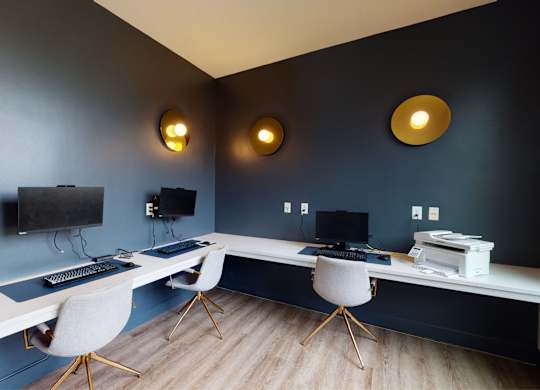 A room with a desk, chairs, and a television.