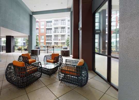 Two black wire baskets with orange cushions sit on a tiled floor.