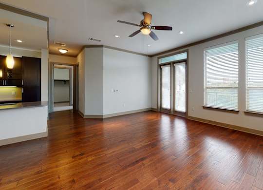 A room with a ceiling fan and wooden flooring.