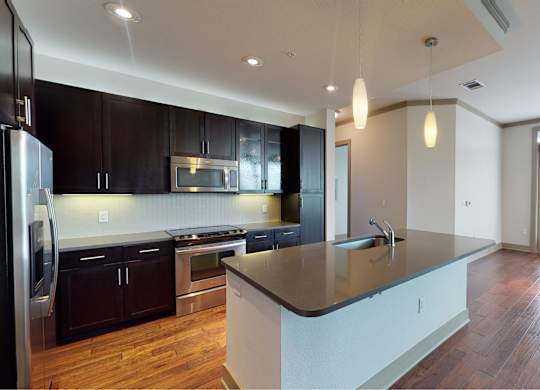 A modern kitchen with dark wood cabinets and a central island