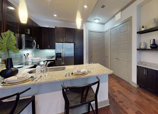 A kitchen with a table set for two and a counter top.