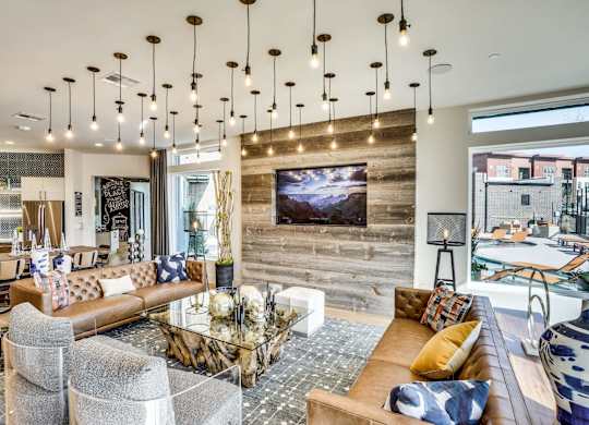 A modern living room with a large couch and a television mounted on the wall.