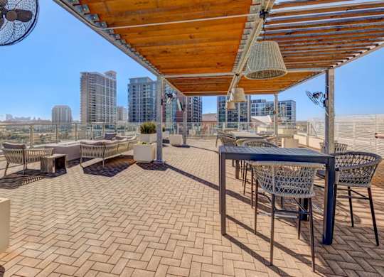 A patio with a table and chairs under a roof.