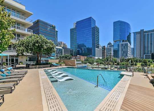 A swimming pool with a city skyline in the background.