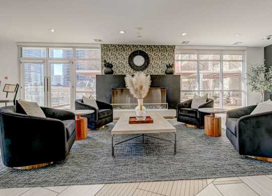 A living room with black and white furniture and a large window.