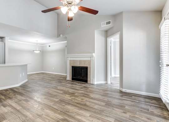 A living room with a fireplace and wood flooring.