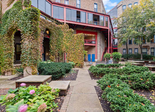 A building with a red and white facade is surrounded by greenery.