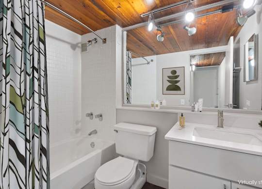 A white toilet sits next to a white sink in a bathroom.