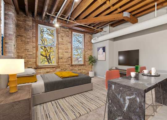 A bedroom with a bed, a table, and a television.
