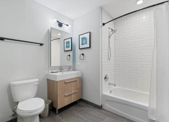 A white bathroom with a toilet, sink, and bathtub.