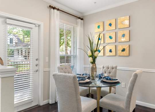 A dining room with a glass table and chairs.