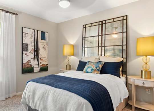 A bedroom with a bed, nightstand, and two lamps.