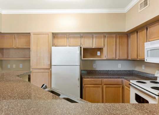 A kitchen with wooden cabinets and a white refrigerator.
