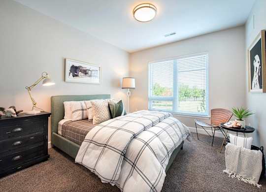 Luxury Apartments in Berkley Riverfront, MO, with In-Unit Washer and Dryer - Union Berkley - Living Room with Wood-Style Flooring, Area Rug, Sofa, Wooden Chest Coffee Table, Armchair, and Floor Lamp.
