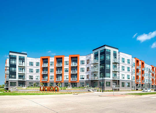 Luxury Apartments in Berkley Riverfront, MO - Union Berkley - Exterior of Apartment Complex with Paved Driveway, Sidewalks, Landscaping, and Property Signage.