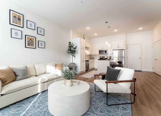 A living room with a white couch, a white coffee table, and a white chair.