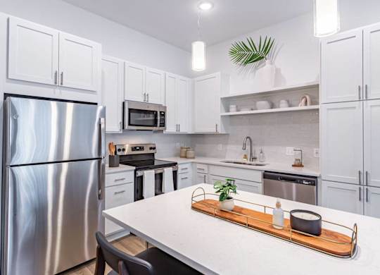 A modern kitchen with a stainless steel refrigerator and white cabinets.
