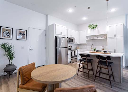 A modern kitchen with a dining table and chairs.