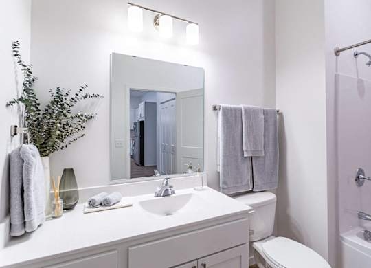 A white bathroom with a white sink and toilet.
