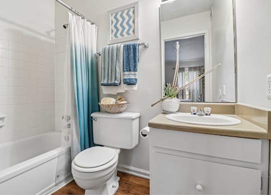 A white toilet sits next to a white sink in a bathroom.