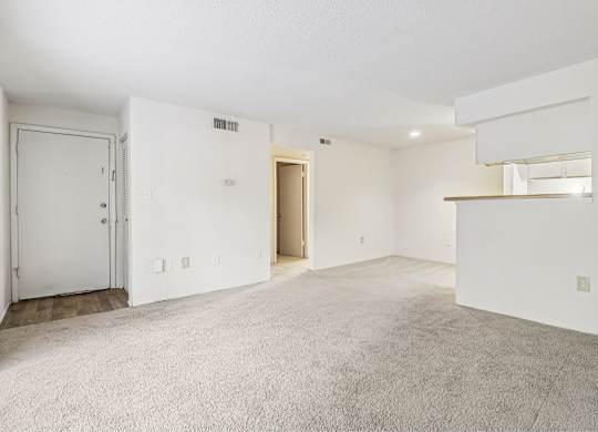 A large, empty room with a door and a window.