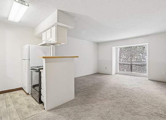 A white kitchen with a refrigerator, oven, and microwave.