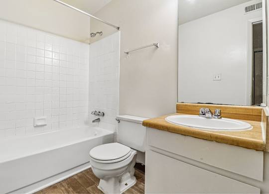 A white bathroom with a toilet, sink, and bathtub.