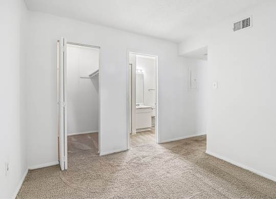 A white room with a carpeted floor and a white door.