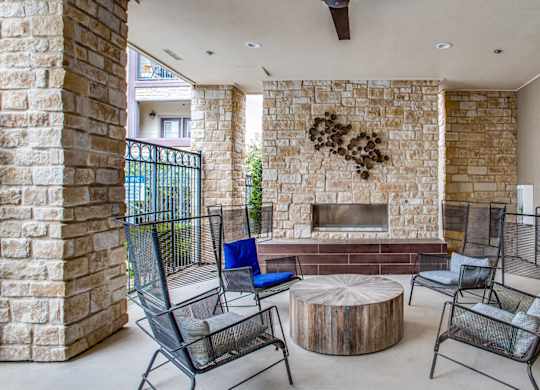 Resident clubhouse with fireplace and lounge seating at Twin Creeks Crossing, apartments in Allen