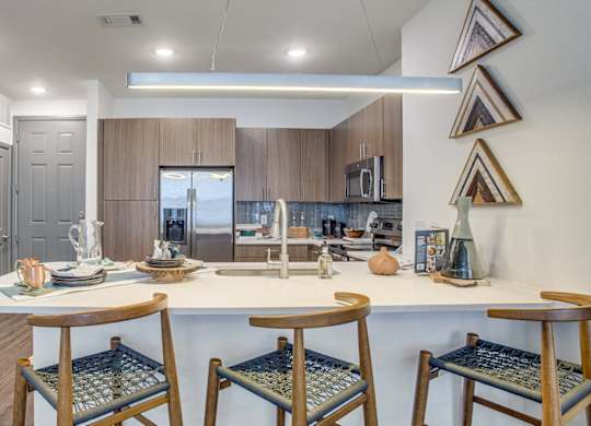 Modern kitchen with large island and stainless steel appliances at Twin Creeks Crossing, apartments in Allen, TX
