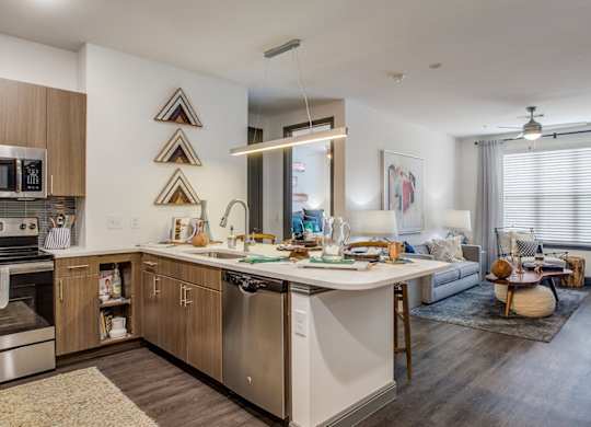 Apartment kitchen with stainless steel appliances and spacious island at Twin Creeks Crossing in Allen, TX