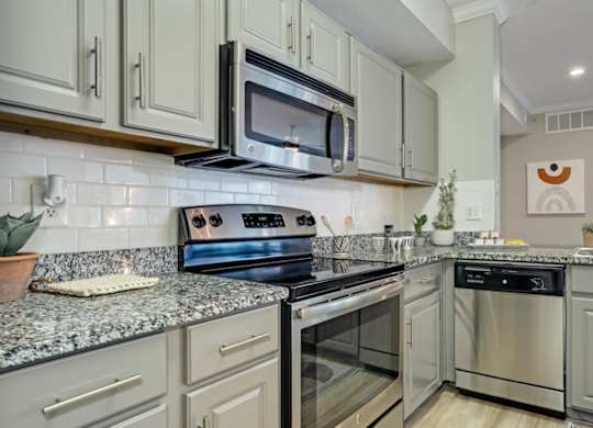 Kitchen with granite countertops and stainless steel appliances at The Lana, Dallas apartments