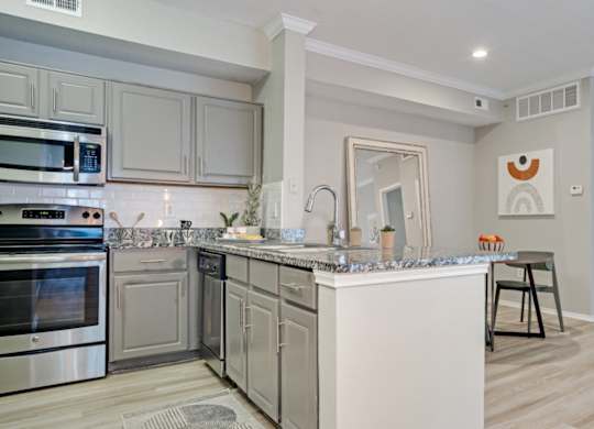 Open kitchen with stainless steel appliances at The Lana, North Dallas apartments