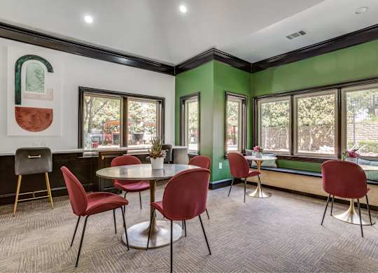 A room with green walls and a table with red chairs.