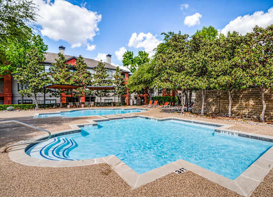 Outdoor pool surrounded by landscaping at The Lana, luxury apartments Dallas,TX