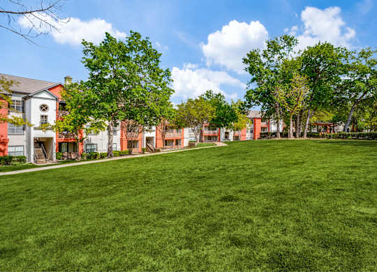 A grassy area in front of a row of apartments at The Lana in North Dallas, TX