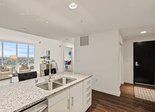 A modern kitchen with a large island and a view of the city.