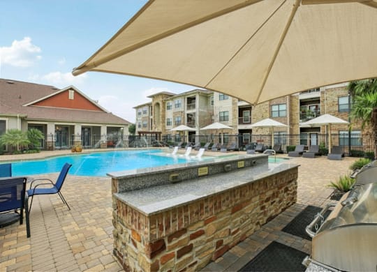 A pool area with a stone wall and a hot tub.