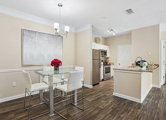 A dining room with a glass table and chairs.