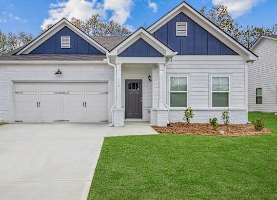 a white house with a black door and a driveway