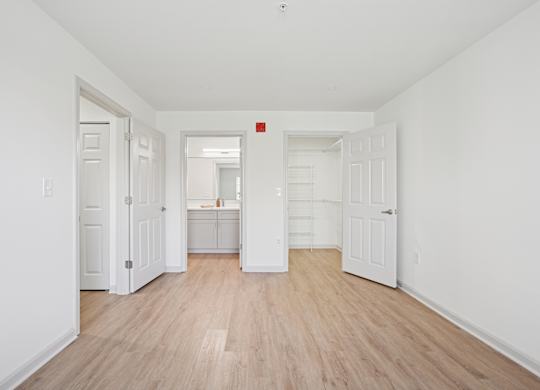 A room with white walls and wooden flooring with a red square on the wall.