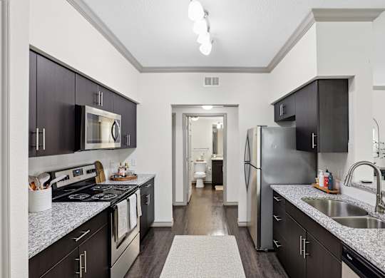 A kitchen with dark brown cabinets and a white counter top.