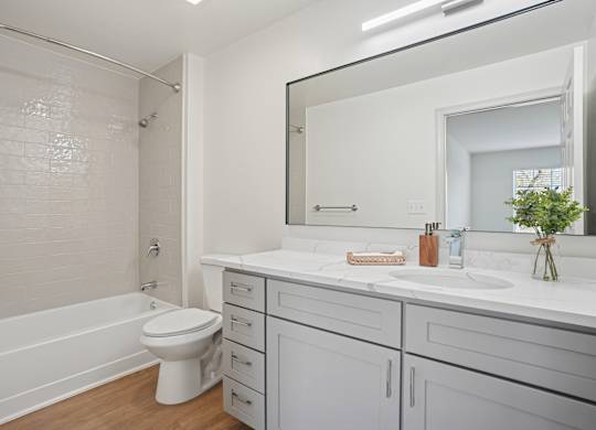 A white bathroom with a toilet, sink, and mirror.