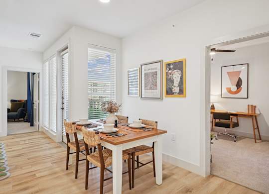 A dining room with a table and chairs.