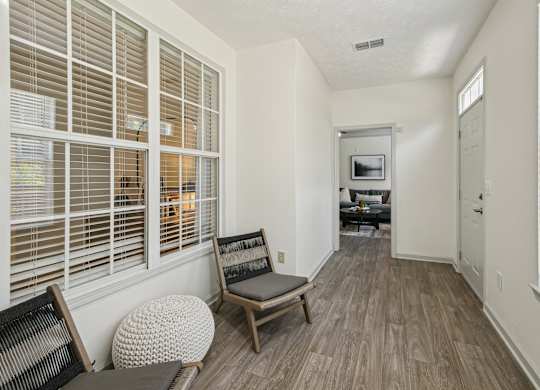 A room with a chair and a table with a television on the wall.