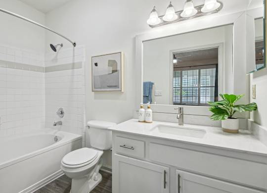 A white bathroom with a toilet, sink, and tub.