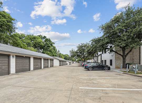 parking lot with garages and cars parked