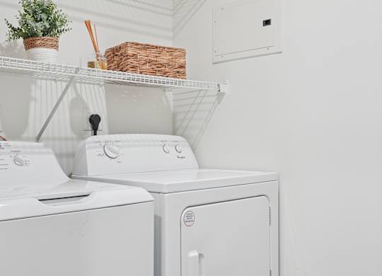A white washing machine and dryer in a laundry room.