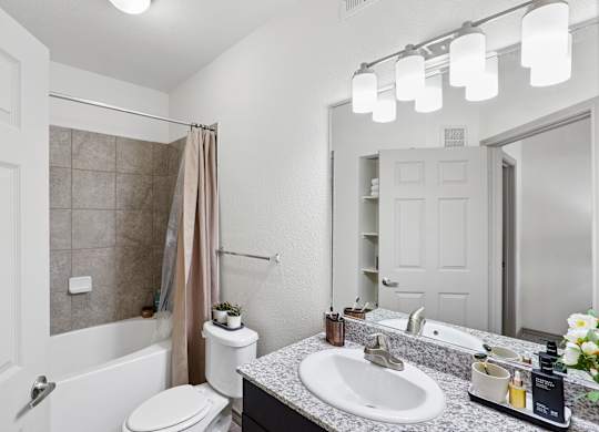 A bathroom with a toilet, sink, and shower.