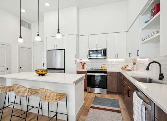 A kitchen with a white countertop and a stainless steel oven.